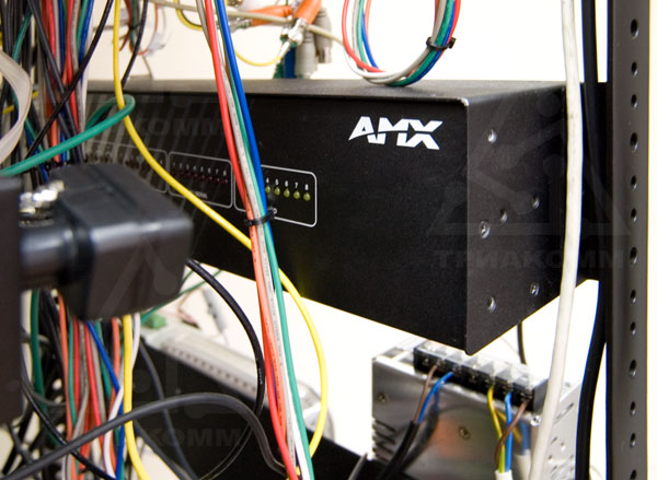 Контроллер AMX NetLinx NI-3000 стоит в стойке с аппаратурой сзади