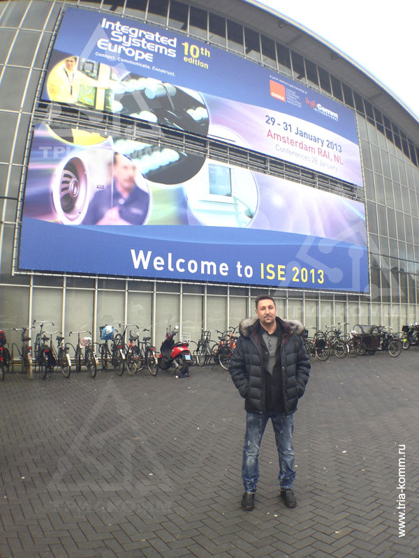 Генеральный директор Андрей Васильев на фоне рекламных баннеров ISE 2013 в Амстердаме