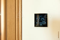 Фото термостата Thermokon LCF Touch с сенсорной панелью управления в главной спальне квартиры